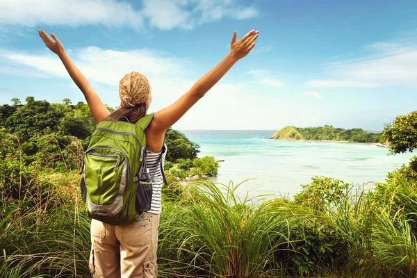 Senderista con mochila disfrutando de vistas al mar desde la cima de una montaña — Foto de Stock