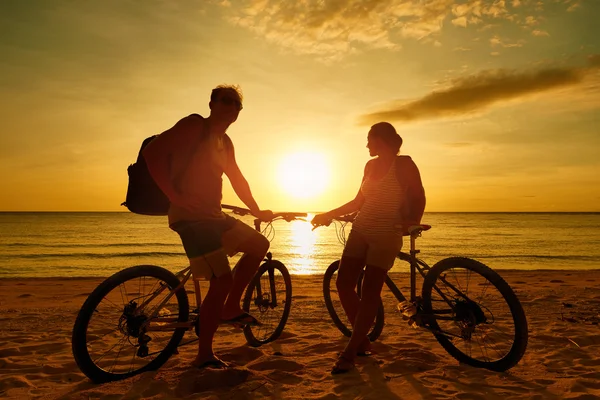 Couple tourists with Bicycles Watching Sunset. Silhouette people — Stock Photo, Image