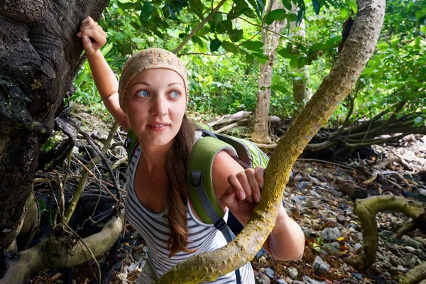 Young tourist with backpack walking in tropical forest — Stock Photo, Image