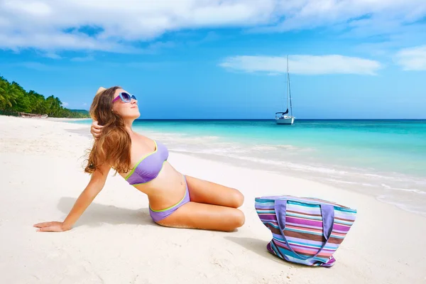 Hermosa mujer en bikini tomando el sol en la playa — Foto de Stock