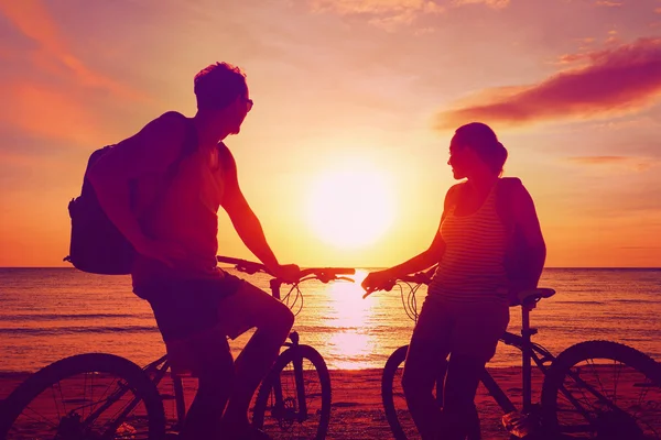 自転車を見て夕日と観光客のカップル。シルエット人 — ストック写真