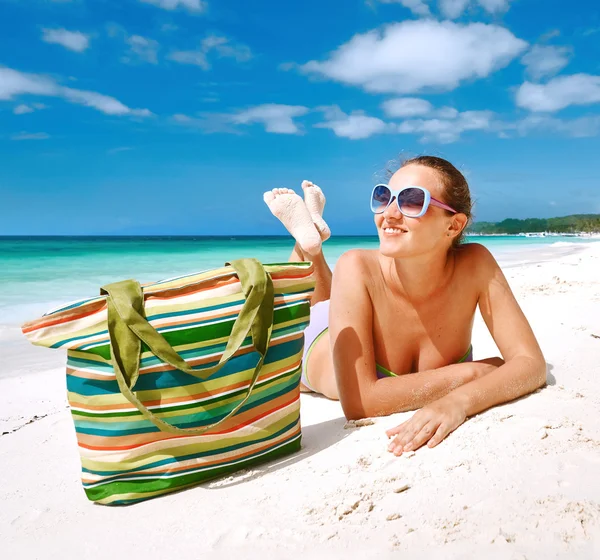 Lächelnde schöne Frau sonnt sich am Strand Stockfoto