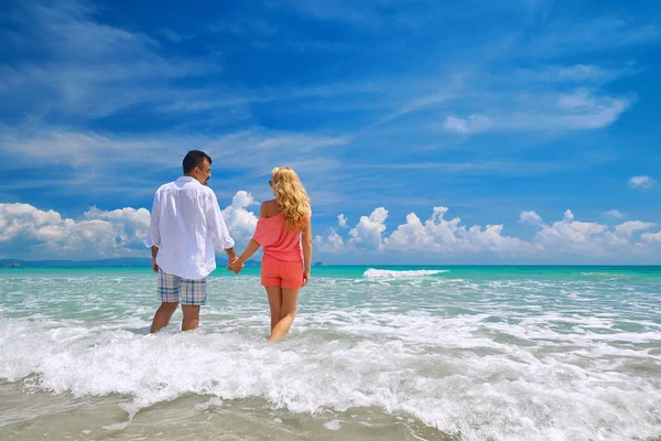 Felice giovane coppia romantica in piedi sulla spiaggia e guardando — Foto Stock