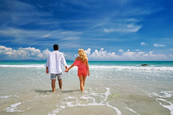 Jong (echt) paar bedrijf handen op strand genieten van de romantiek. — Stockfoto