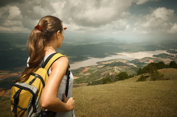 Mujer excursionista con mochila de pie en la cima de la montaña y en — Foto de Stock