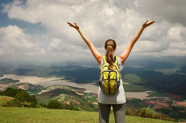 Portrait of happy traveler woman with backpack standing on top o — Stock Photo, Image