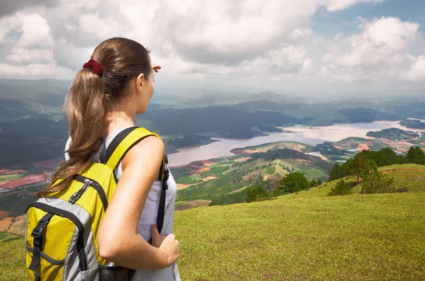 O tânără excursionistă cu rucsac în picioare pe vârful muntelui — Fotografie, imagine de stoc