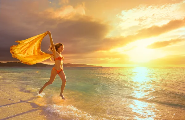 Unbeschwerte junge Frau im Sonnenuntergang am Strand. schöner Sonnenuntergang. — Stockfoto