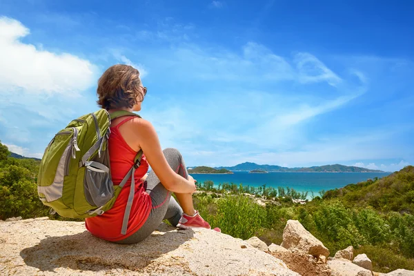 Turista com mochila relaxante no topo da montanha e desfrutar — Fotografia de Stock