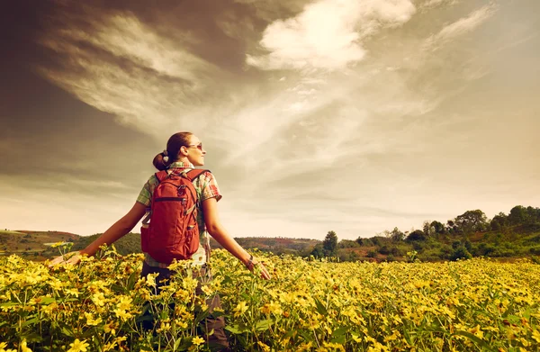 Junge Wanderin wandert auf dem Hintergrund farbiger Felder. — Stockfoto