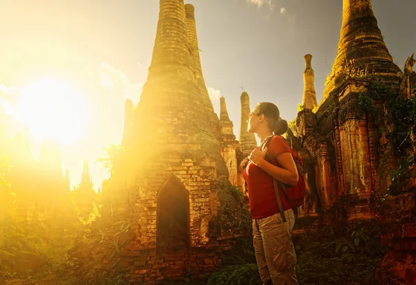 Woman backpacker traveling  with backpack and looks at sunset an — Stock Photo, Image