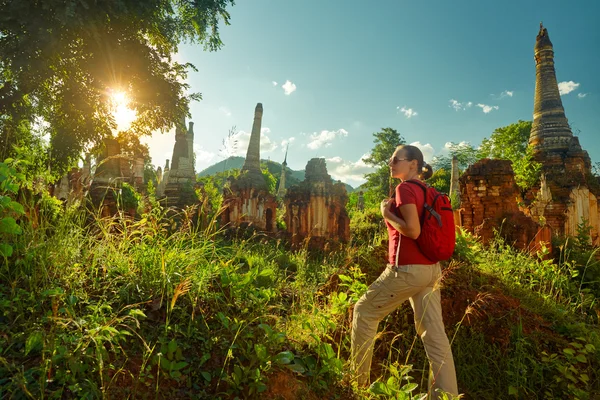 Pengembara perempuan dengan ransel berjalan dan melihat matahari terbenam di antara — Stok Foto