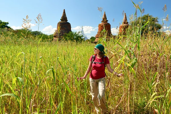 Backpacker walking and looking to field to ancient buddhist stup — стоковое фото