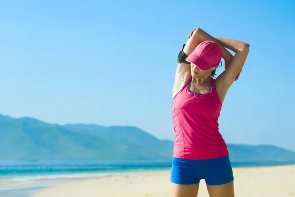 Jovem mulher fazendo exercício de alongamento na praia . — Fotografia de Stock