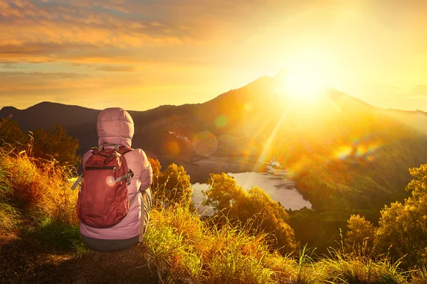 Yüksek dağlar, gündoğumu manzarayı backpacker kadınla. — Stok fotoğraf