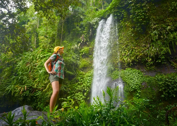 Mutlu genç kadın backpacker ormanlarda şelale bakarak — Stok fotoğraf