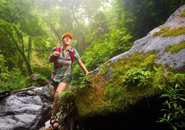 Young woman tourist with a backpack walking along the trail in t — Stock Photo, Image