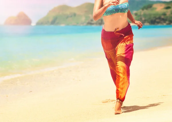 Mujer en verano pantalones sueltos corriendo en la playa tropical —  Fotos de Stock