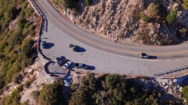 Kızıl Kaya Sahnesi 'nin yüksek hava yörüngesi Dünya Sahne Geçidi boyunca San Bernardino Ulusal Ormanı' nda renkli sonbahar yaprakları ve görkemli dağlarla çevrili.