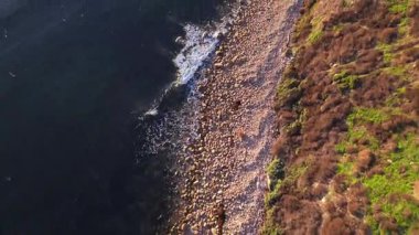 Güneş batarken, okyanusun üzerindeki engebeli kayalıkları ve evleri aydınlatan, nefes kesici Lunada Körfezi 'nin sinematik hava gösterimi, Palos Verdes Emlak, Kaliforniya