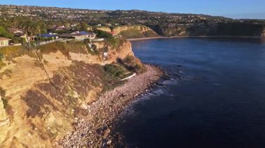 Güneş batarken, okyanusun üzerindeki engebeli kayalıkları ve evleri aydınlatan, nefes kesen Lunada Körfezi 'nin hava üssü, Palos Verdes Emlak, Kaliforniya
