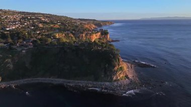 Güneş batarken nefes kesici Palos Verdes kıyı şeridini gösteren hava sarmalı, okyanusun üzerindeki engebeli kayalıkları ve evleri aydınlatıyor, Palos Verdes Evleri, Kaliforniya