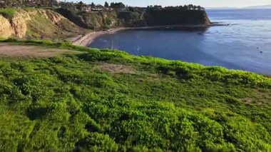 Güneş batarken, okyanusun üzerindeki engebeli kayalıkları ve evleri aydınlatan, nefes kesen Lunada Körfezi 'nin hava üssü, Palos Verdes Emlak, Kaliforniya