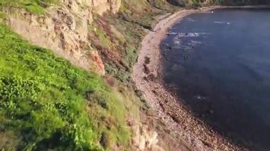 Güneş batarken, okyanusun üzerindeki engebeli kayalıkları ve evleri aydınlatan, nefes kesici Lunada Körfezi 'nin sinematik hava gösterimi, Palos Verdes Emlak, Kaliforniya