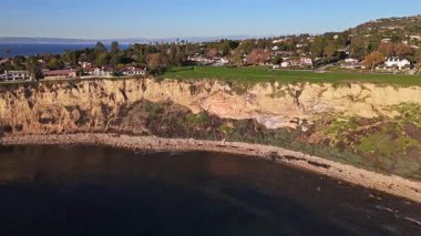 Güneş batarken, okyanusun üzerindeki engebeli kayalıkları ve evleri aydınlatan, nefes kesen Lunada Körfezi 'nin yüksek hava üssü, Palos Verdes Emlak, Kaliforniya
