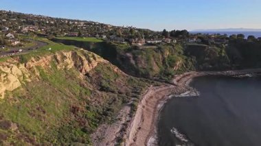 Güneş batarken, okyanusun üzerindeki engebeli kayalıkları ve evleri aydınlatan, nefes kesen Lunada Körfezi 'nin yüksek hava üssü, Palos Verdes Emlak, Kaliforniya