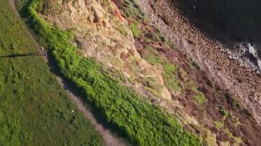 Güneş batarken, okyanusun üzerindeki engebeli kayalıkları ve evleri aydınlatan, nefes kesici Lunada Körfezi 'nin sinematik hava gösterimi, Palos Verdes Emlak, Kaliforniya