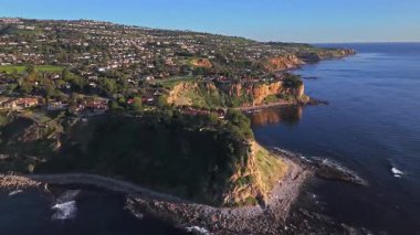 Güneş batarken Palos Verdes 'in nefes kesen sahili, okyanusun üzerindeki engebeli kayalıkları ve evleri aydınlatan, Palos Verdes Evleri, Kaliforniya