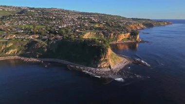 Güneş batarken Palos Verdes 'in nefes kesen sahili, okyanusun üzerindeki engebeli kayalıkları ve evleri aydınlatan, Palos Verdes Evleri, Kaliforniya