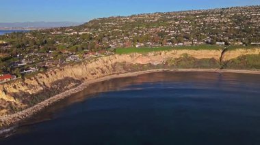 Güneş batarken, okyanusun üzerindeki engebeli kayalıkları ve evleri aydınlatan, nefes kesen Lunada Körfezi 'nin yüksek hava baskını görüntüleri, Palos Verdes Emlak, Kaliforniya