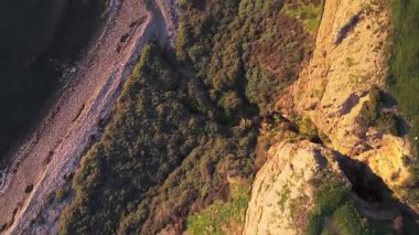Güneş batarken, okyanusun üzerindeki engebeli kayalıkları ve evleri aydınlatan, nefes kesici Lunada Körfezi 'nin sinematik hava gösterimi, Palos Verdes Emlak, Kaliforniya