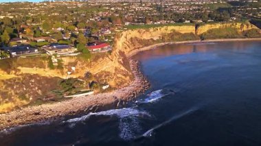 Güneş batarken, okyanusun üzerindeki engebeli kayalıkları ve evleri aydınlatan, nefes kesen Lunada Körfezi 'nin yüksek hava baskını görüntüleri, Palos Verdes Emlak, Kaliforniya