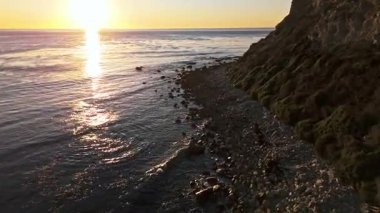 Güneş batarken Lunada Körfezi 'nin alçak hava geçidi kayalık kıyı şeridine çarpıyor, Palos Verdes Emlak, Kaliforniya