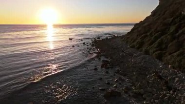 Güneş batarken Lunada Körfezi 'nin alçak hava geçidi kayalık kıyı şeridine çarpıyor, Palos Verdes Emlak, Kaliforniya