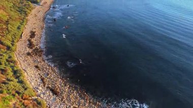 Güneş batarken, okyanusun üzerindeki engebeli kayalıkları ve evleri aydınlatan, nefes kesici Lunada Körfezi 'nin sinematik hava gösterimi, Palos Verdes Emlak, Kaliforniya