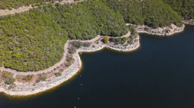 Güneşli bir sonbahar gününde, engebeli kayalıklar ve muhteşem göl evleri Austin, Teksas 'ta nefes kesici Travis Gölü kıyılarının yüksek yörünge görüntüsü.