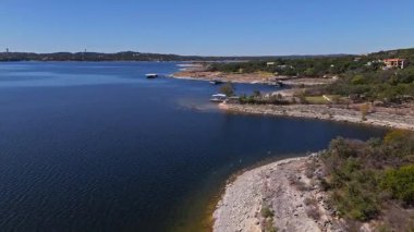 Güneşli bir sonbahar gününde, engebeli uçurumlar ve çarpıcı göl evleri Austin, Teksas 'ta alçak havadan esen Travis Gölü kıyıları.