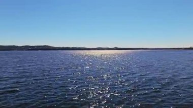 Güneşli bir sonbahar gününde, alçak hava akıntısı Travis Gölü engebeli kayalıkları ve çarpıcı göl evleri, Austin, Teksas