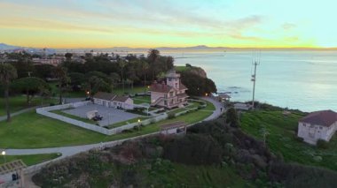 Point Fermin 'in mavi saatinde Los Angeles, Kaliforniya' daki hava çekimleri. Renkli gökyüzü, engebeli uçurumlar ve kıyıya vuran dalgalar.