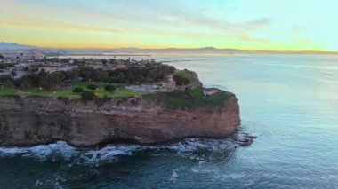 Point Fermin 'in Los Angeles, Kaliforniya' daki mavi saat görüntülerine hava saldırısı. Renkli gökyüzü, engebeli uçurumlar ve kıyı boyunca dalgalar çarpışıyor.