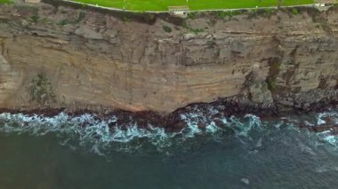 Point Fermin 'in renkli gökyüzü, engebeli uçurumlar ve kıyıya vuran dalgalarla gündoğumunda Los Angeles, Kaliforniya' daki sinematik hava aracı görüntüleri.
