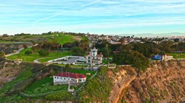 Los Angeles, Kaliforniya 'daki Point Fermin Deniz Feneri' nin alçak hava sarmal görüntüsü. Renkli gökyüzü, engebeli uçurumlar ve kıyıya vuran dalgalar.
