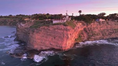 Point Fermin 'in mavi saatte Los Angeles, Kaliforniya' daki yüksek hava çekimi. Renkli gökyüzü, engebeli uçurumlar ve kıyıya vuran dalgalar.