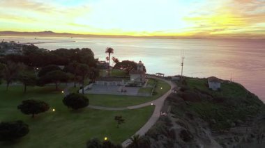 Los Angeles, Kaliforniya 'daki Point Fermin' in mavi saat uçuşu. Renkli gökyüzü, engebeli uçurumlar ve kıyıya vuran dalgalar.