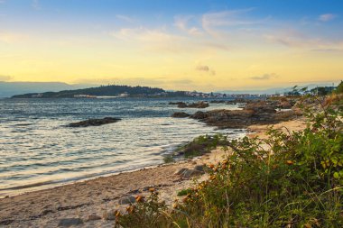 Gün batımında Arousa Adası köyü ile sahil kayalıkları arasında küçük bir sahil.