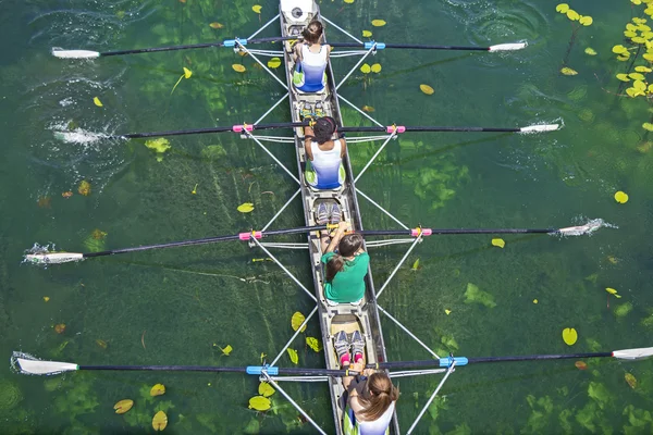 Cuatro mujeres remando en el tranquilo lago — Foto de Stock